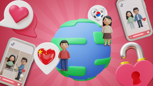 An editorial 3D composite illustration featuring a globe surrounded by various cultural and social media icons against a radiating pink background. A clay-style Chinese man and Korean woman stand on either side of the globe, accompanied by heart-shaped speech bubbles representing their respective national flags. Two floating smartphones display TikTok-inspired interfaces: one showing the couple holding hands and the other depicting them sharing domestic duties like cooking and cleaning. The scene is accented by a large, unlocked heart-shaped padlock, symbolizing the breaking of cultural barriers in modern dating.